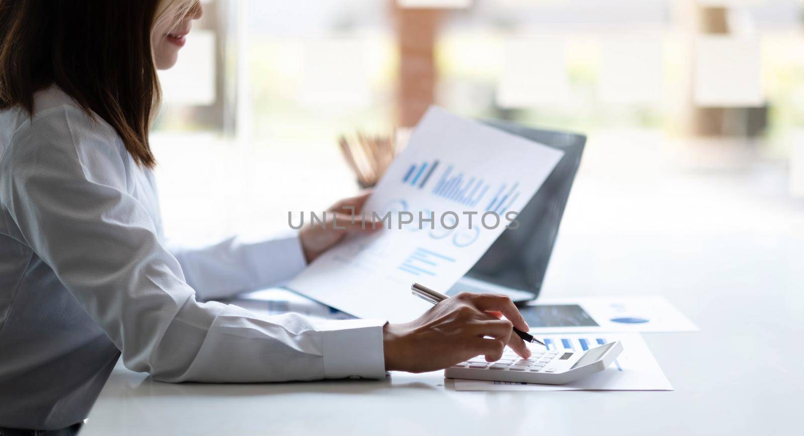 Business woman using calculator for do math finance on wooden desk in office and business working background, tax, accounting, statistics and analytic research concept.