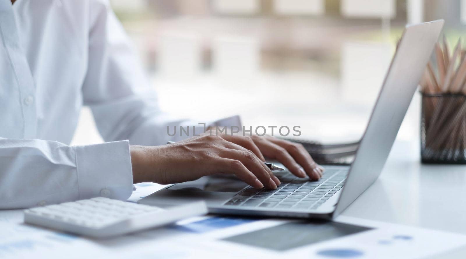 Close up businesswoman using laptop computer keyboard at the office..