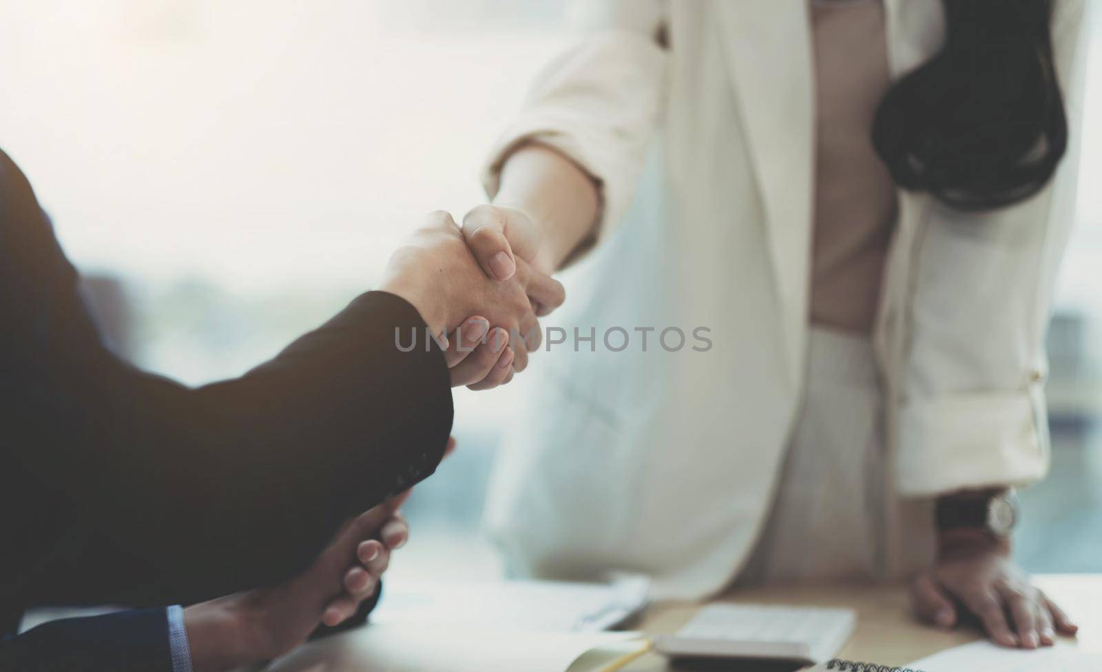 Close up of Business people shaking hands, finishing up meeting, business etiquette, congratulation, merger and acquisition concept by wichayada