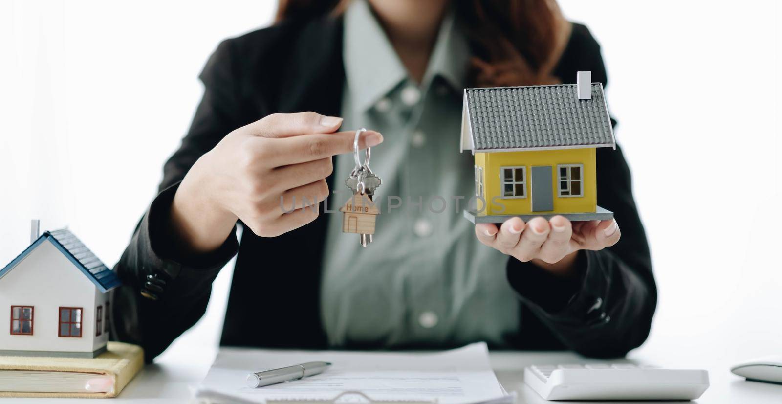 Estate agent are presenting home loan and sending keys to client after signing contract to rental house Insurance with approved property form. by wichayada