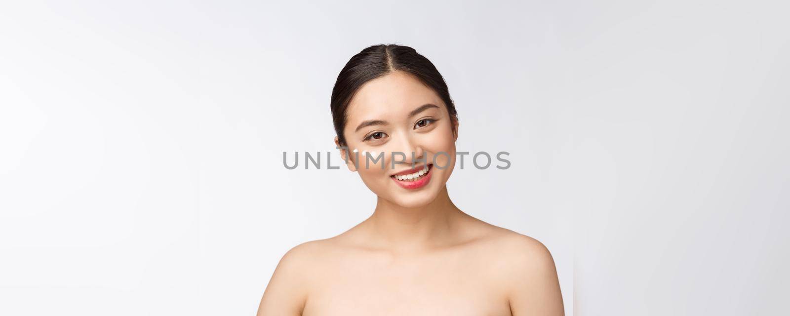 Skin care beauty woman. Beauty woman smiling applying cream. Beauty portrait of beautiful Asian Caucasian female model isolated on white
