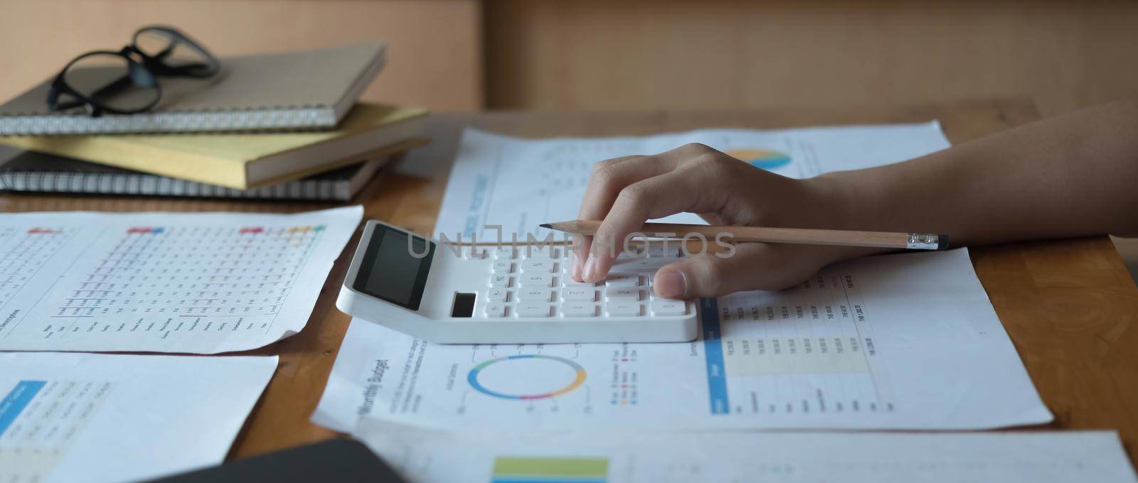 woman working on project for analyzing company financial report balance statement with documents graphics at modern office. business,economy, market,money and tax concept . by wichayada