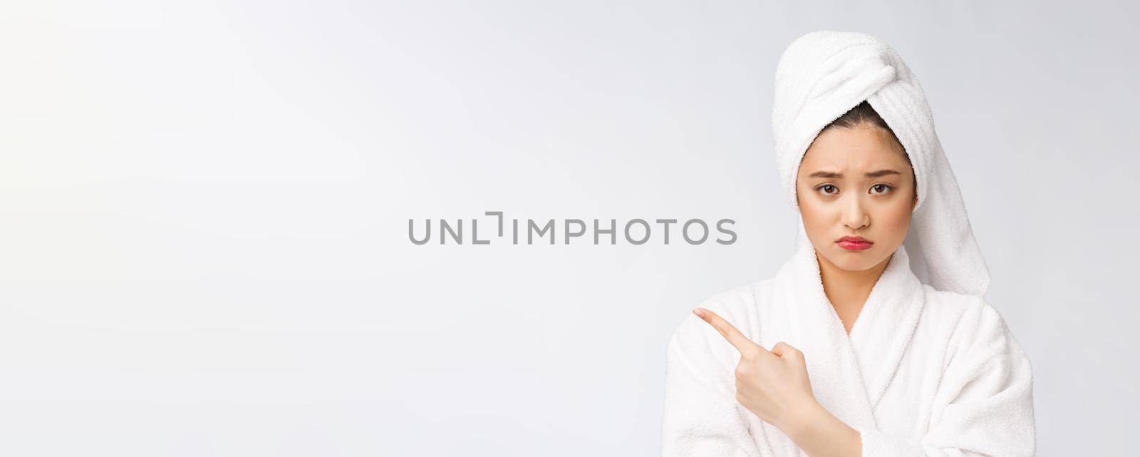 Young beautiful woman wearing shower towel after bath over isolated white background pointing with finger