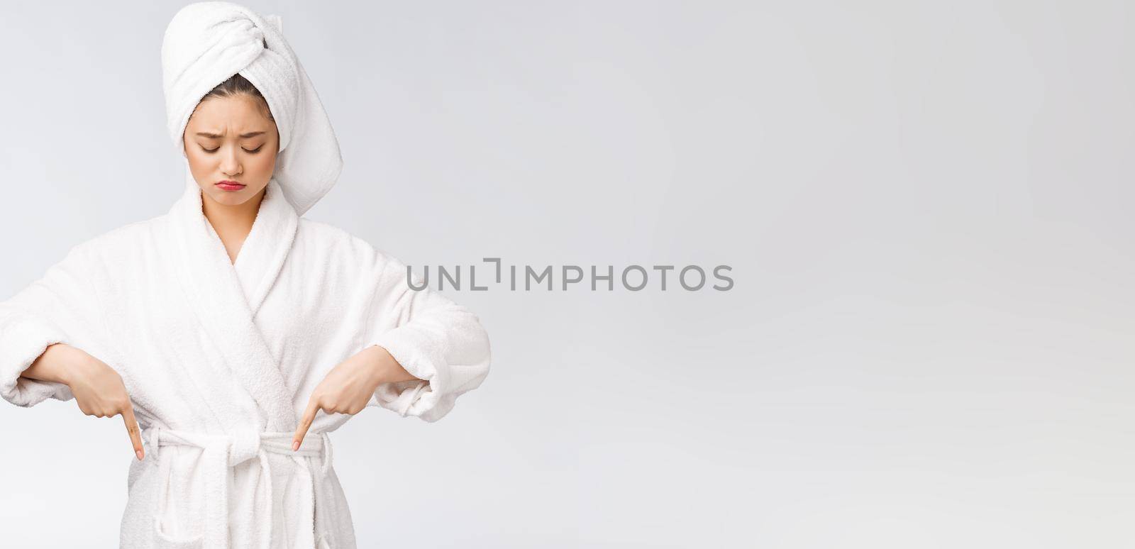 Young beautiful woman wearing shower towel after bath over isolated white background pointing with finger. by Benzoix