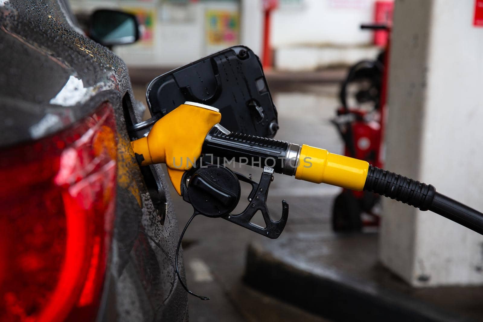 Refueling gun in the gas tank, the concept of increasing fuel prices.