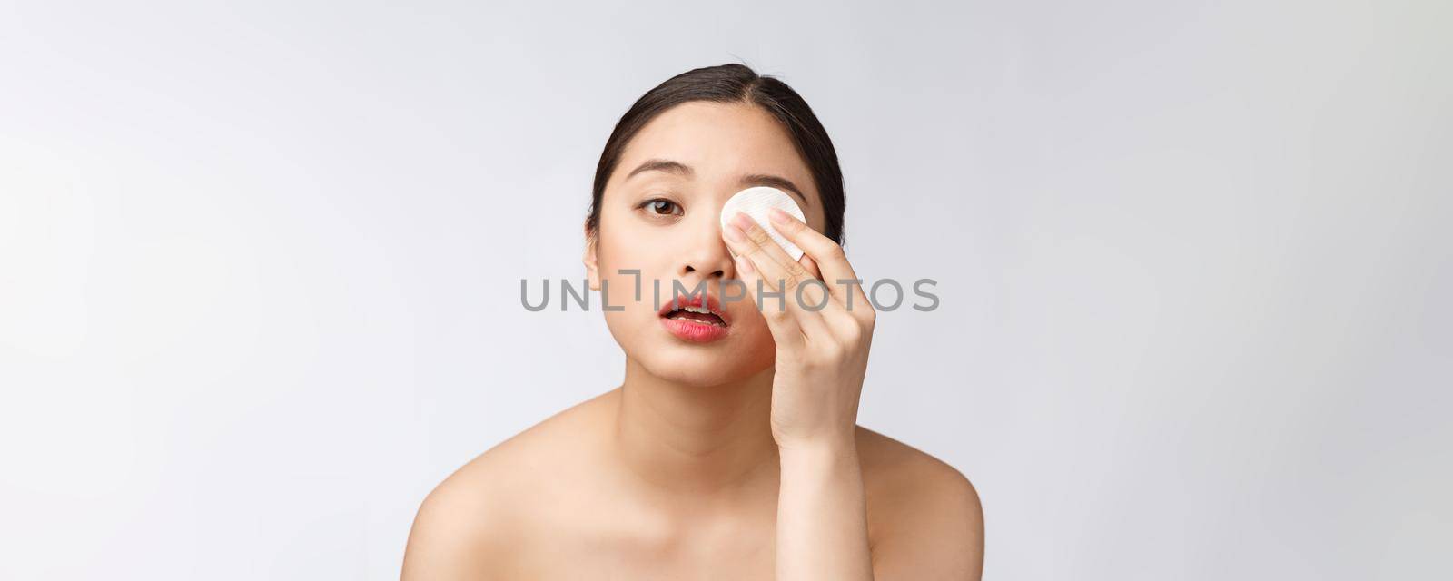 skin care woman removing face makeup with cotton swab pad - skin care concept. Facial closeup of beautiful mixed race model with perfect skin. by Benzoix