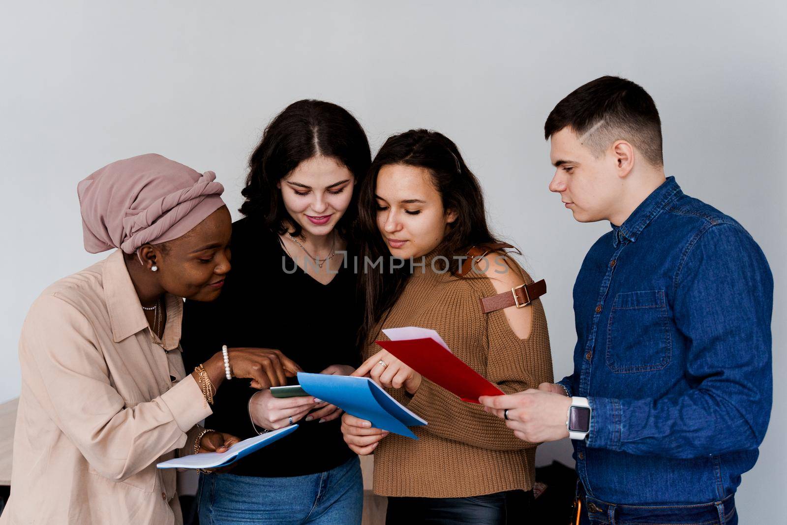 Multiethnic students and teacher study foreign languages together in class. Studing with notebook. Black attractive girl student study with white people together and look into camera