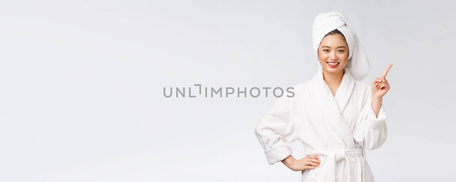 Beauty portrait of young woman showing and pointing finger to empty copy space, asian beauty in bathrobe