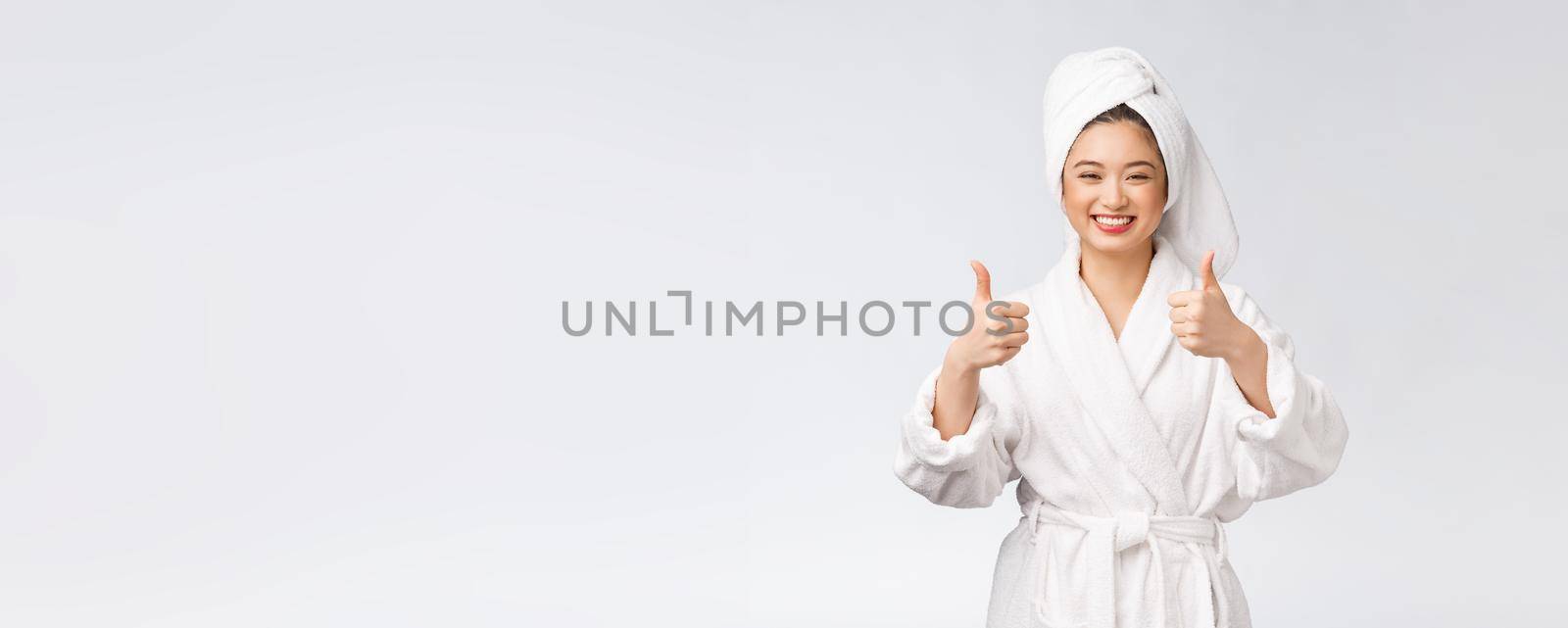 Beautiful asian woman perfect skin showing thumbs up isolated on white background