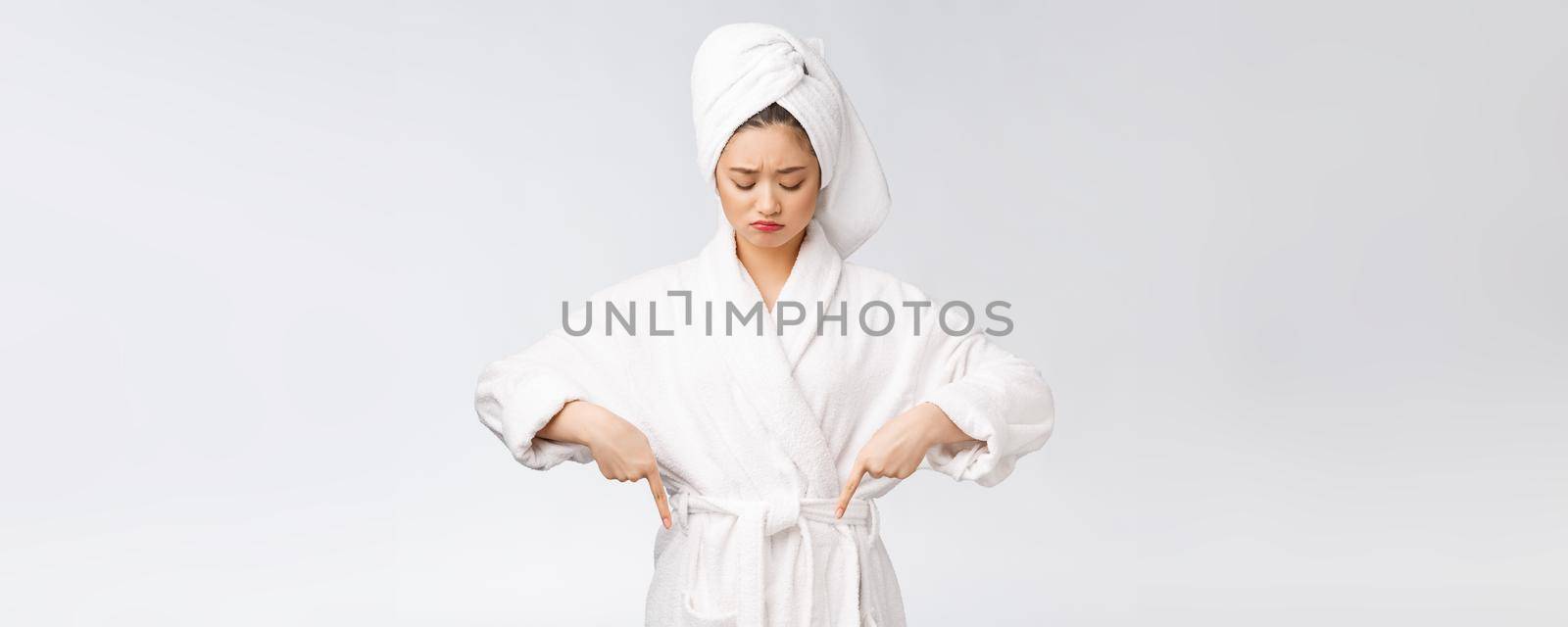 Young beautiful woman wearing shower towel after bath over isolated white background pointing with finger. by Benzoix