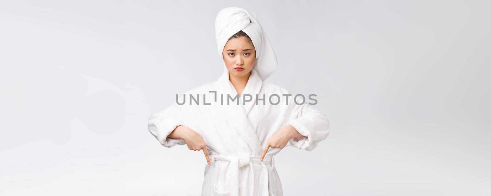 Young beautiful woman wearing shower towel after bath over isolated white background pointing with finger