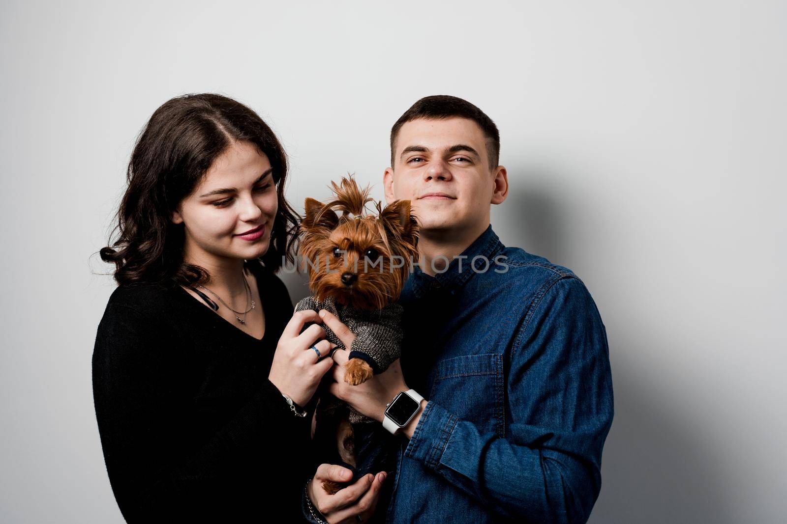 Yorkshire terrier with lovely couple on white background. Happy family with dog. Love to pets by Rabizo
