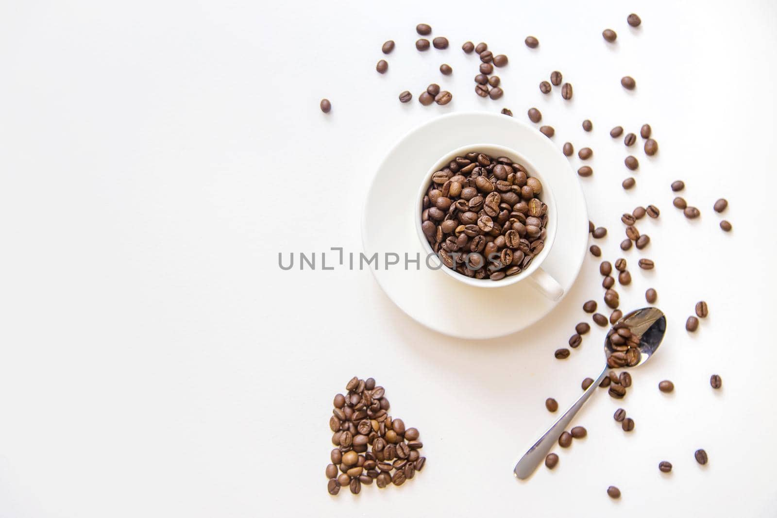 white cup and coffee beans on a white background. Selective focus.