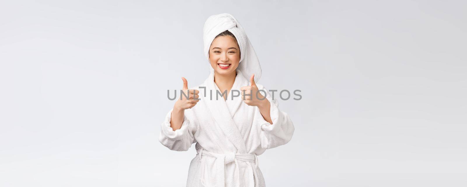 Beautiful asian woman perfect skin showing thumbs up isolated on white background. by Benzoix