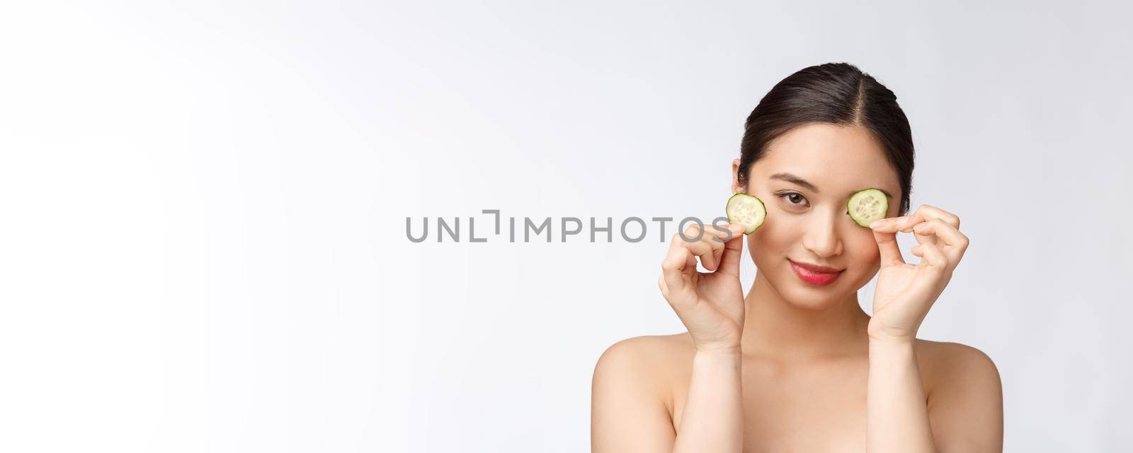 Natural homemade fresh cucumber facial eye pads facial masks. Asian woman holding cucumber pads and smile relax with natural homemade by Benzoix