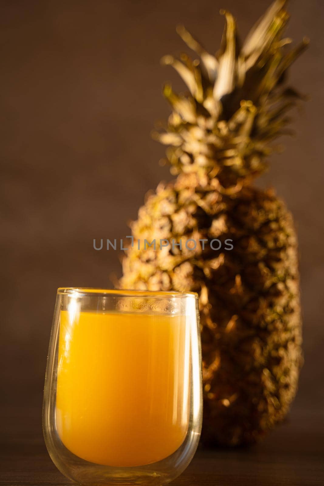 Pineapple fruit and juice in double glass cup. Tropical fruit . Pouring yellow tropical juice into glass.