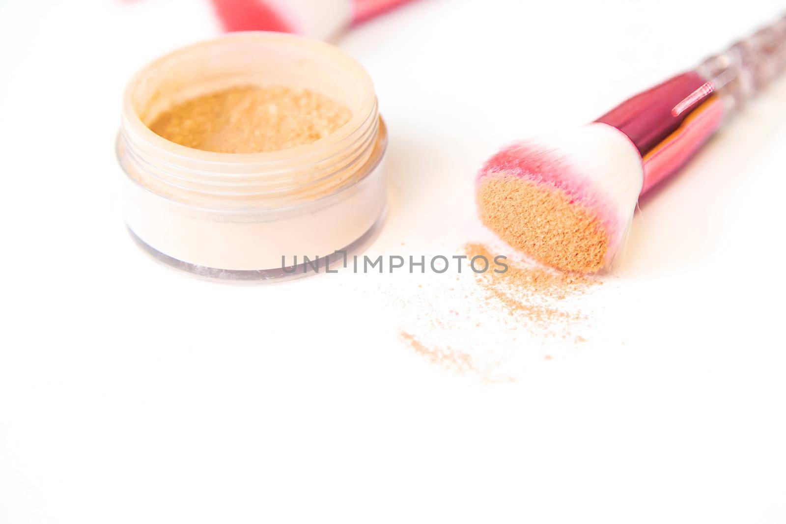Makeup brushes and powder on a white background. Selective focus. by mila1784