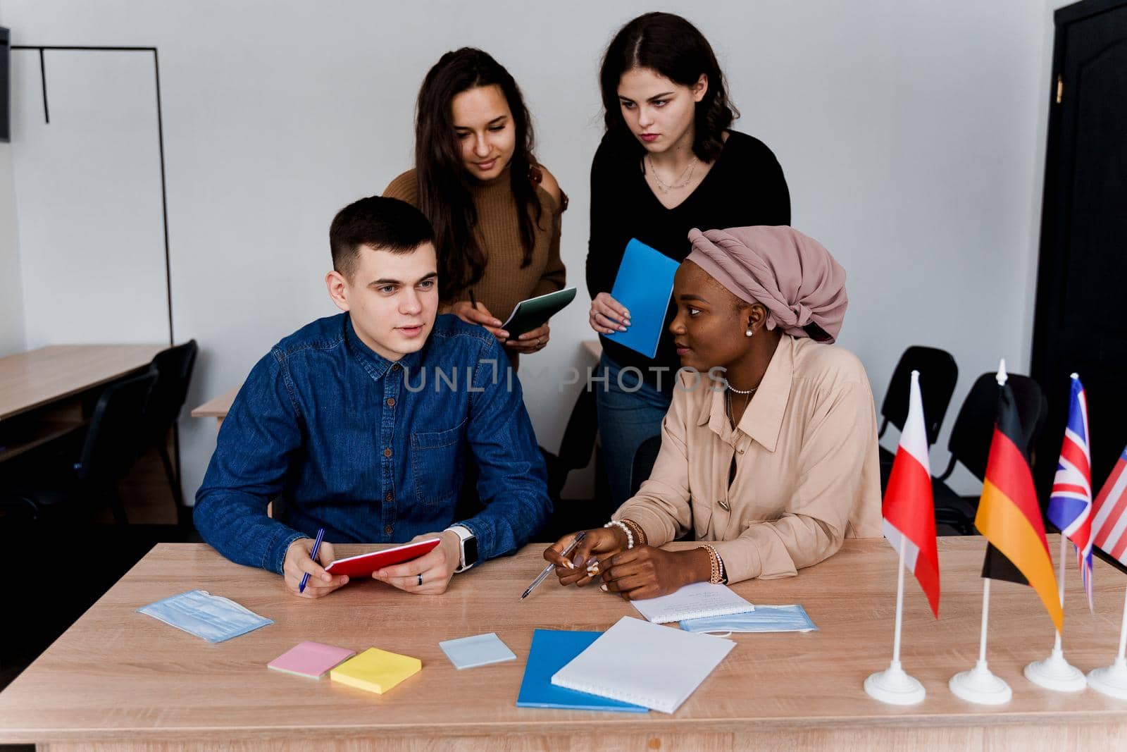 English class study with students from diffent countries: Poland, Germany, USA. Teamwork. Working in multiethnic students. Teacher study foreign languages together in class. Studing with laptop by Rabizo