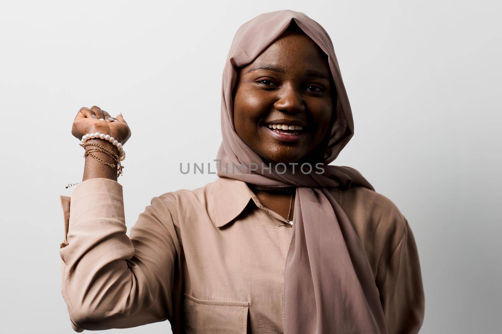 Happy and funny black girl on white background. Young muslim woman smiling in studio. Advert for social network.