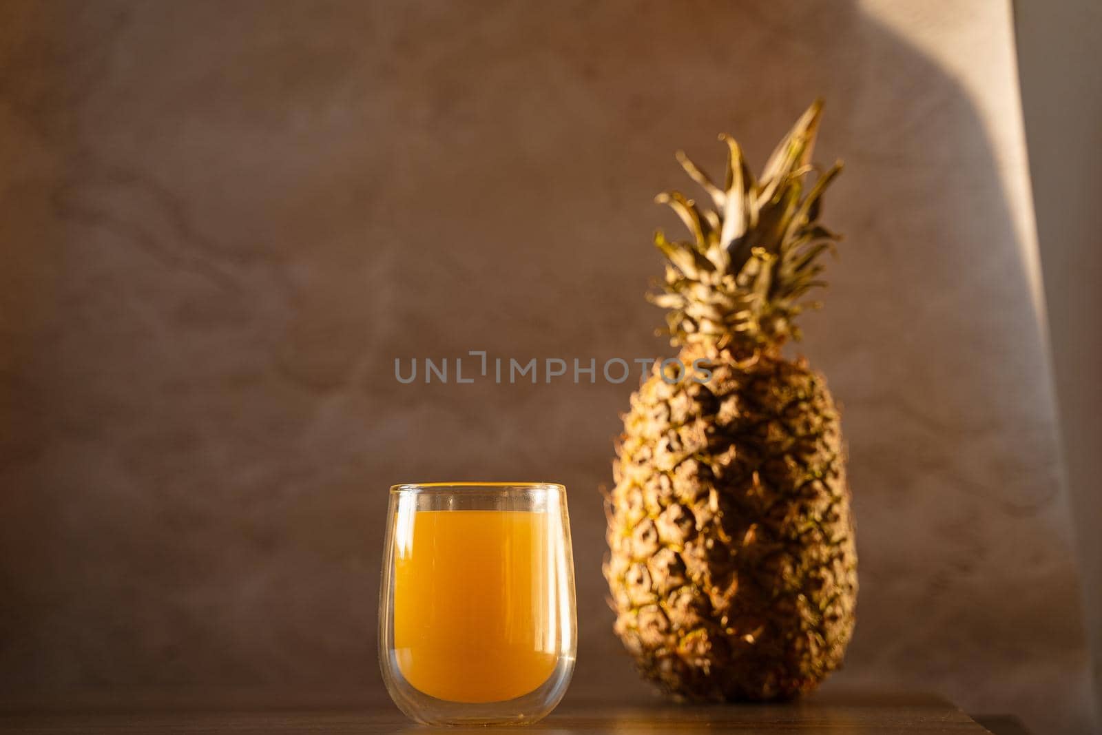 Pineapple fruit and juice in double glass cup. Tropical fruit . Pouring yellow tropical juice into glass by Rabizo