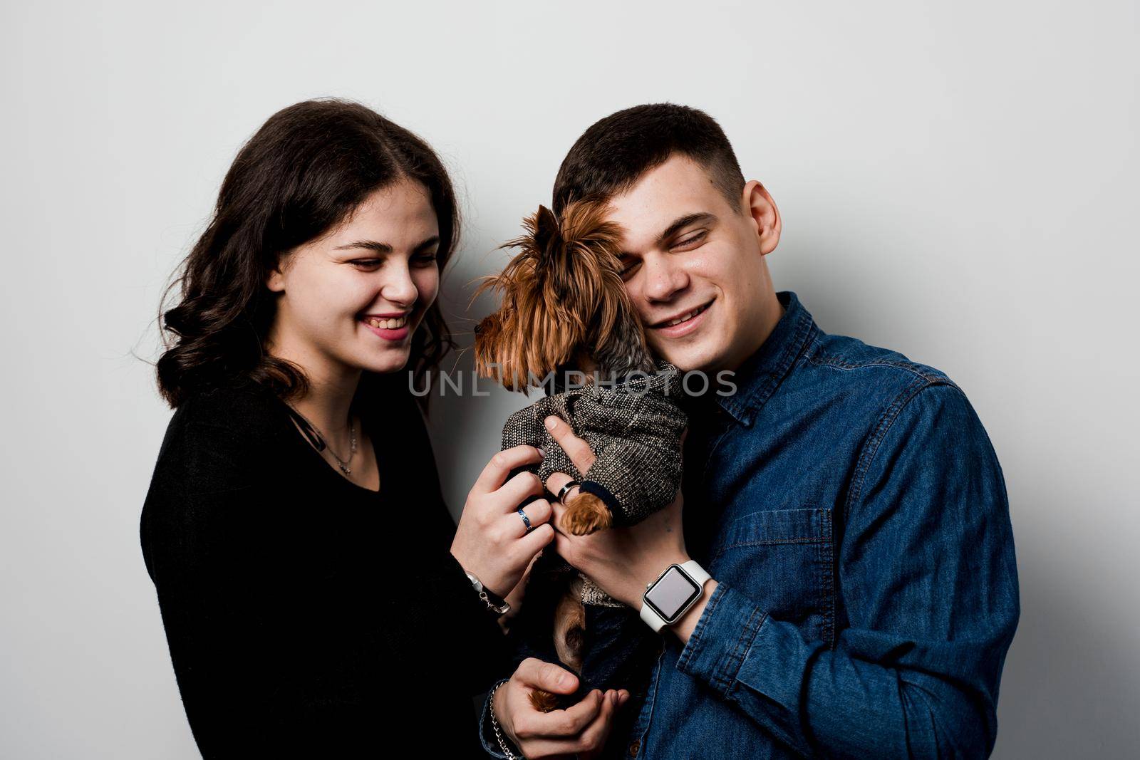 Yorkshire terrier with lovely couple on white background. Happy family with dog. Love to pets.