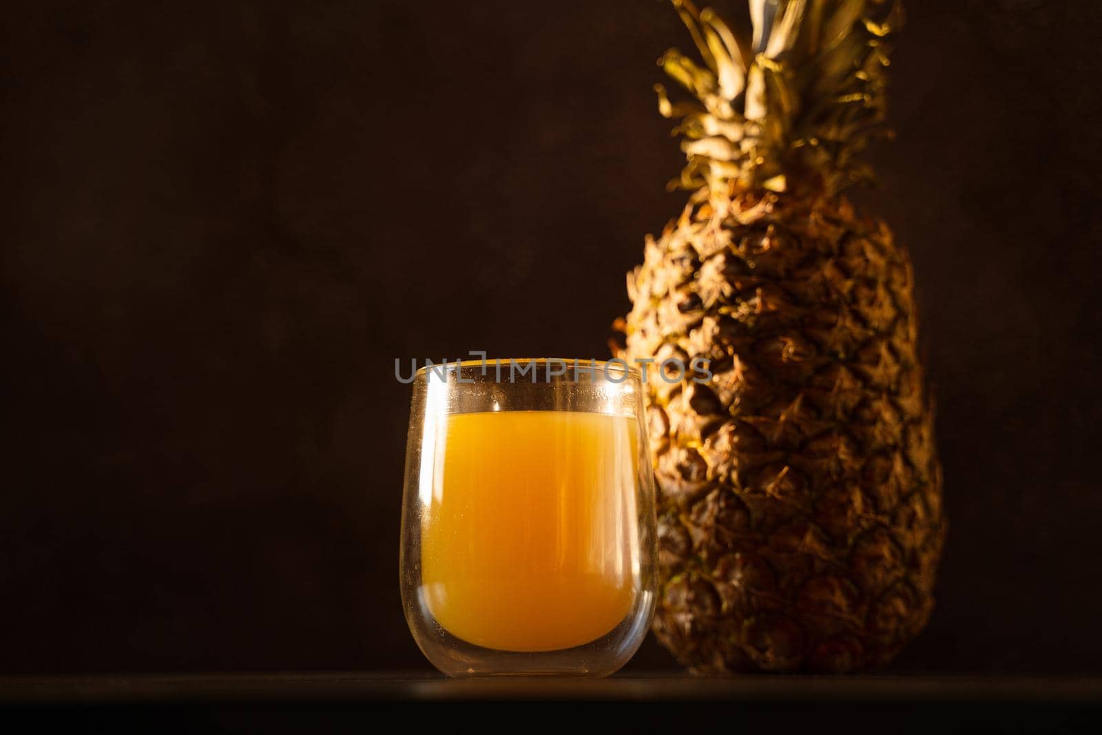 Pineapple fruit and juice in double glass cup. Tropical fruit . Pouring yellow tropical juice into glass.