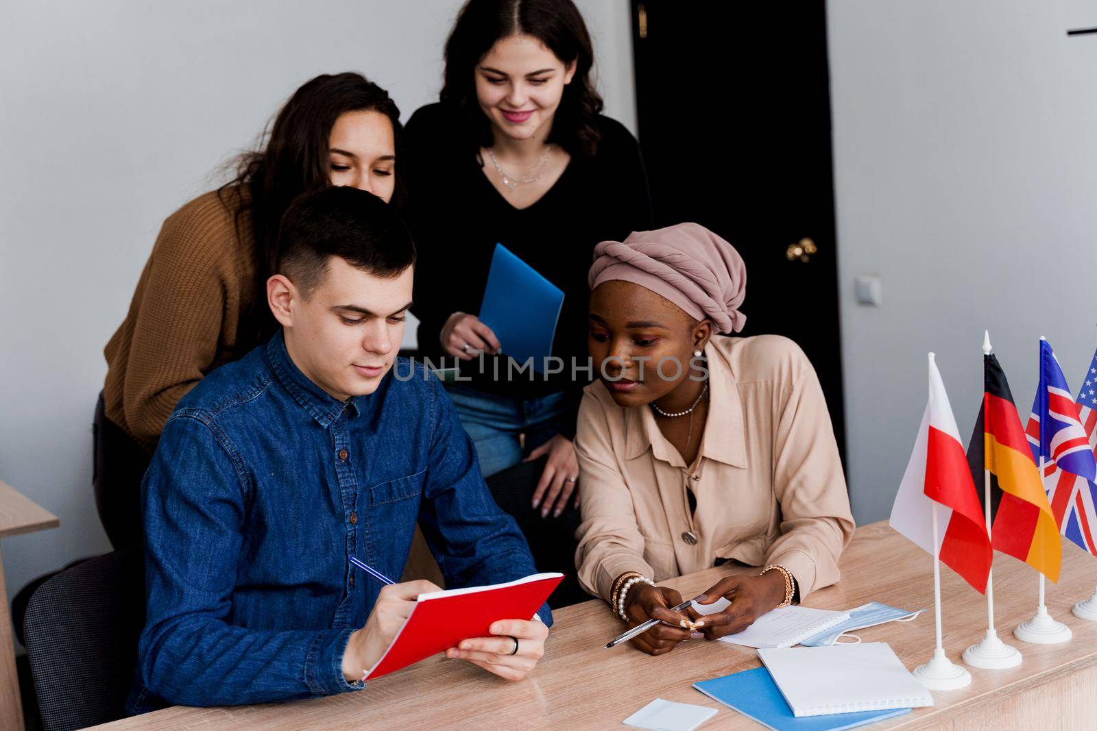 English class study with students from diffent countries: Poland, Germany, USA. Teamwork. Working in multiethnic students. Teacher study foreign languages together in class. Studing with laptop by Rabizo