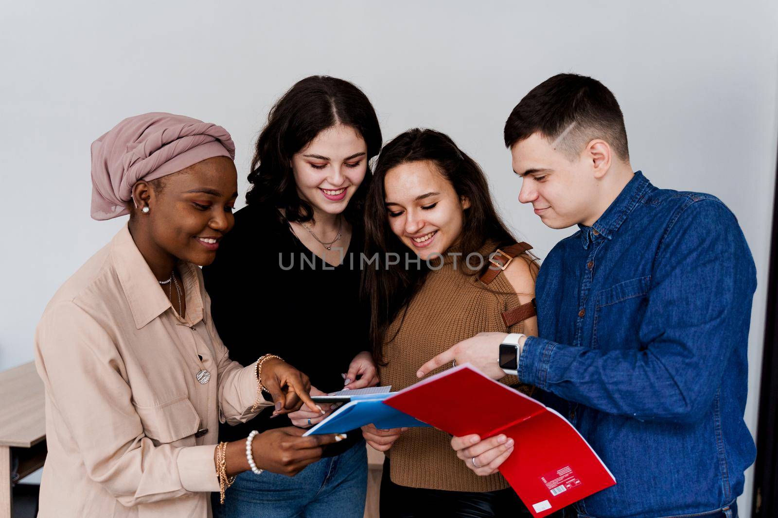 English class study with students from diffent countries: Poland, Germany, USA. Teamwork. Working in multiethnic students. Teacher study foreign languages together in class. Studing with laptop.