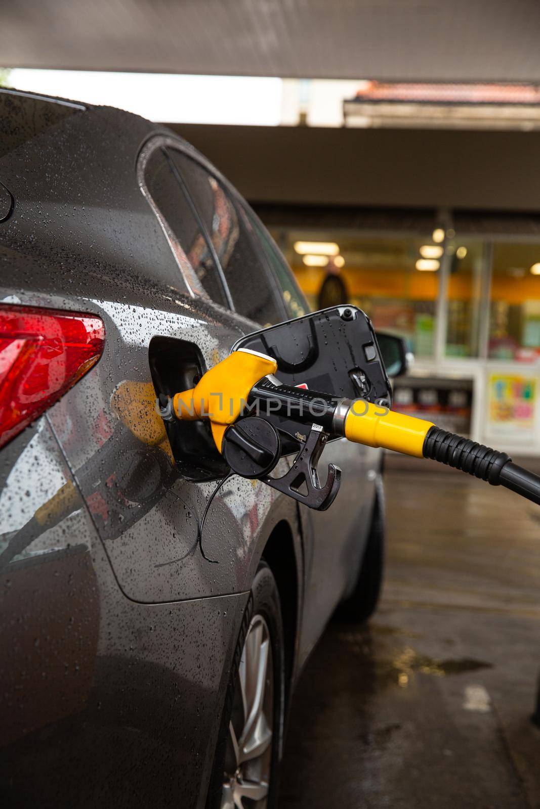 Filling Car With gasoline At Petrol Station Car refueling fuel on petrol station. Service is filling gas or biodiesel into the tank. by RecCameraStock