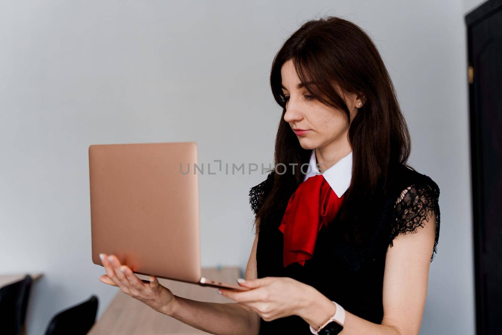 Teacher with laptop on white background. . Foreign school private study with a school girl. Teacher explain grammar of native language using laptop.