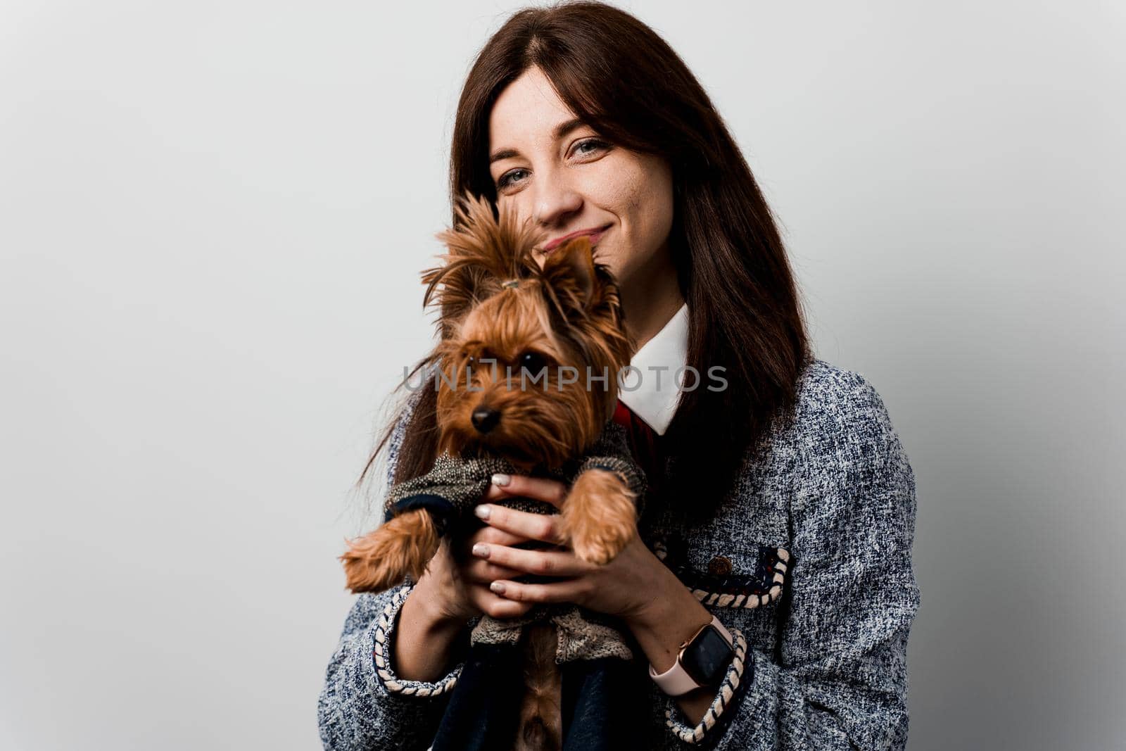 Young attractive woman with dog yorkshire terrier smiles. Close up photo. Pet care. People and pets. Girl holds brown dog isolated on white background