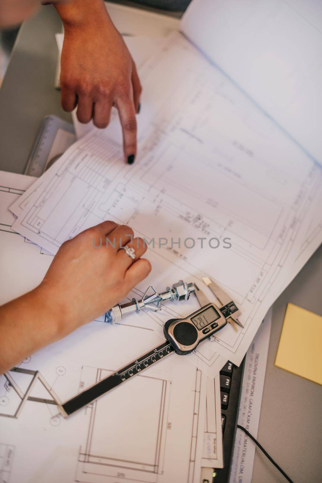 Engineer technician designing drawings mechanical parts engineering Engine.manufacturing factory Industry Industrial work project blueprints measuring bearings caliper tools. High quality photo