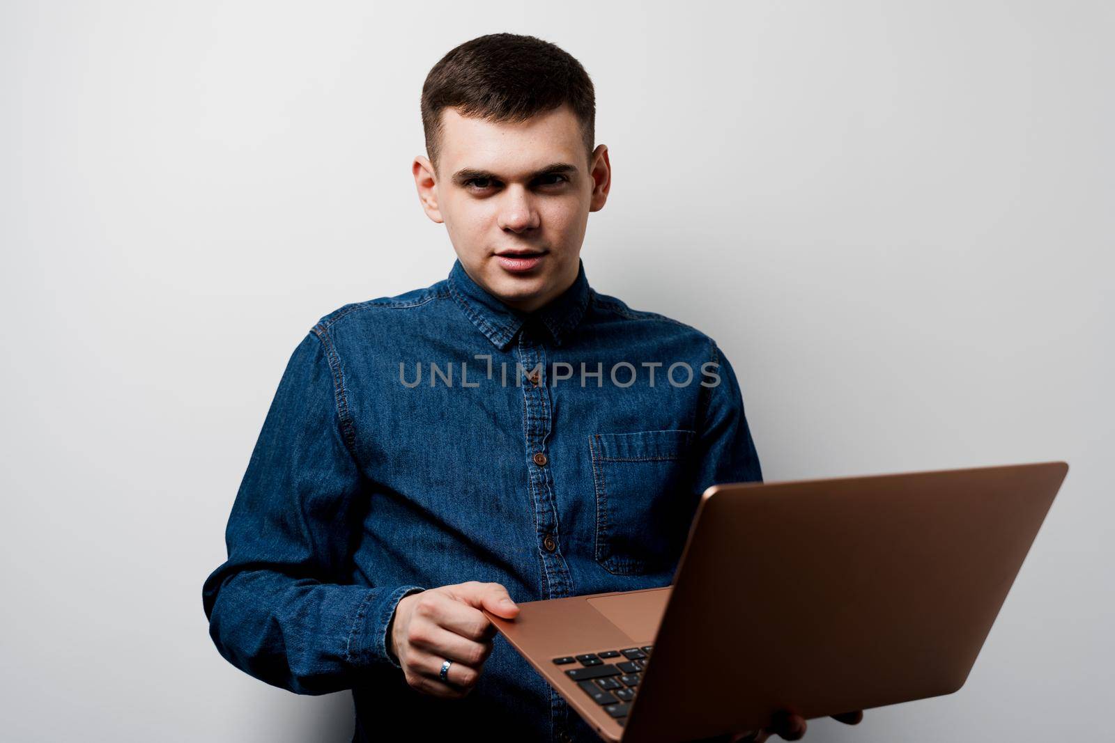 Programmer with laptop works on-line at home. Surfing internet. Handsome man invests in crypto currency bitcoin and earn a lot of money by Rabizo