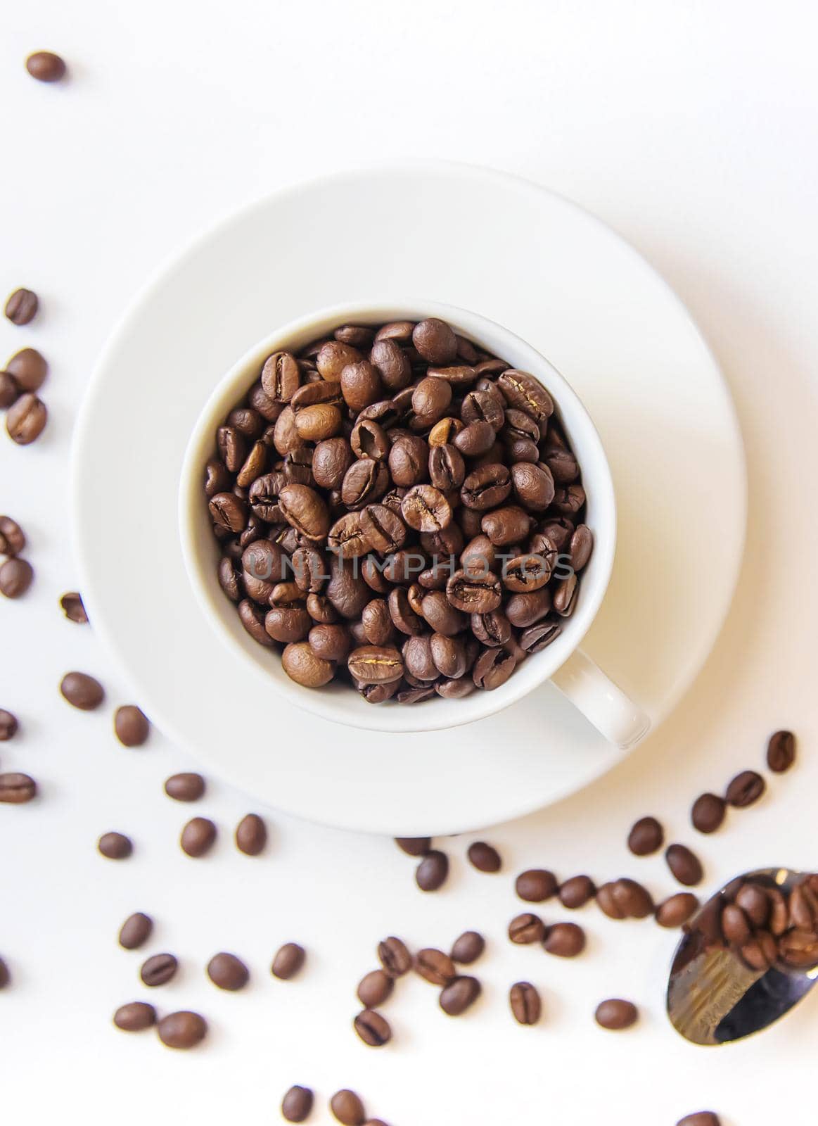 white cup and coffee beans on a white background. Selective focus. by mila1784
