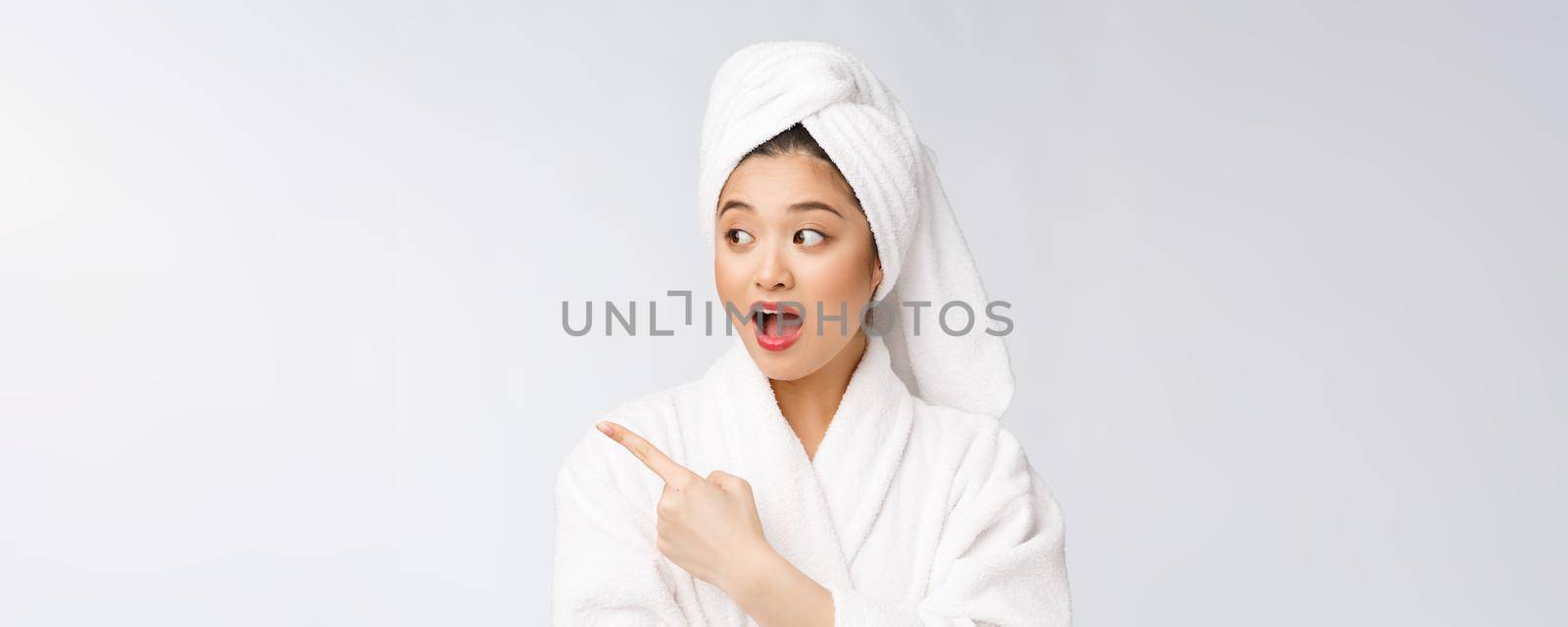 Charming beautiful young woman pointing finger. Attractive beautiful girl get surprise, happiness and love a product, brand, service. by Benzoix