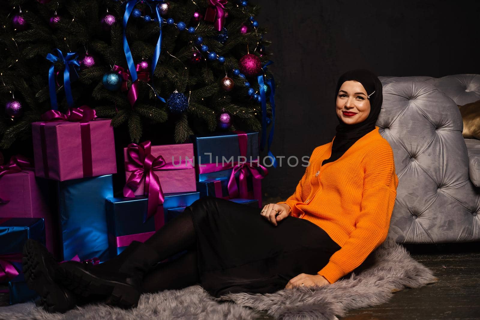 Muslim girl in black hijab is dreaming about gift at new year holiday. Christmas celebration of islamic religion people. by Rabizo