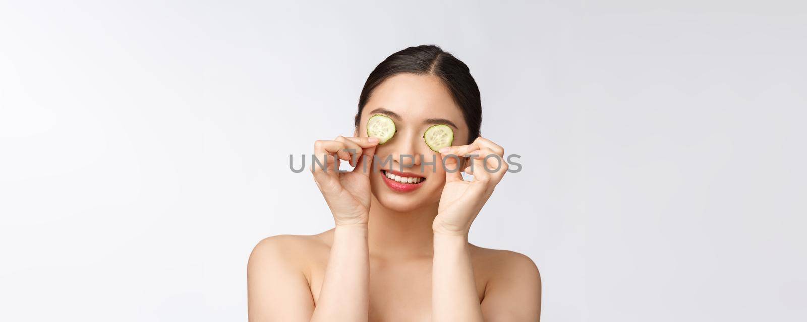 Natural homemade fresh cucumber facial eye pads facial masks. Asian woman holding cucumber pads and smile relax with natural homemade.