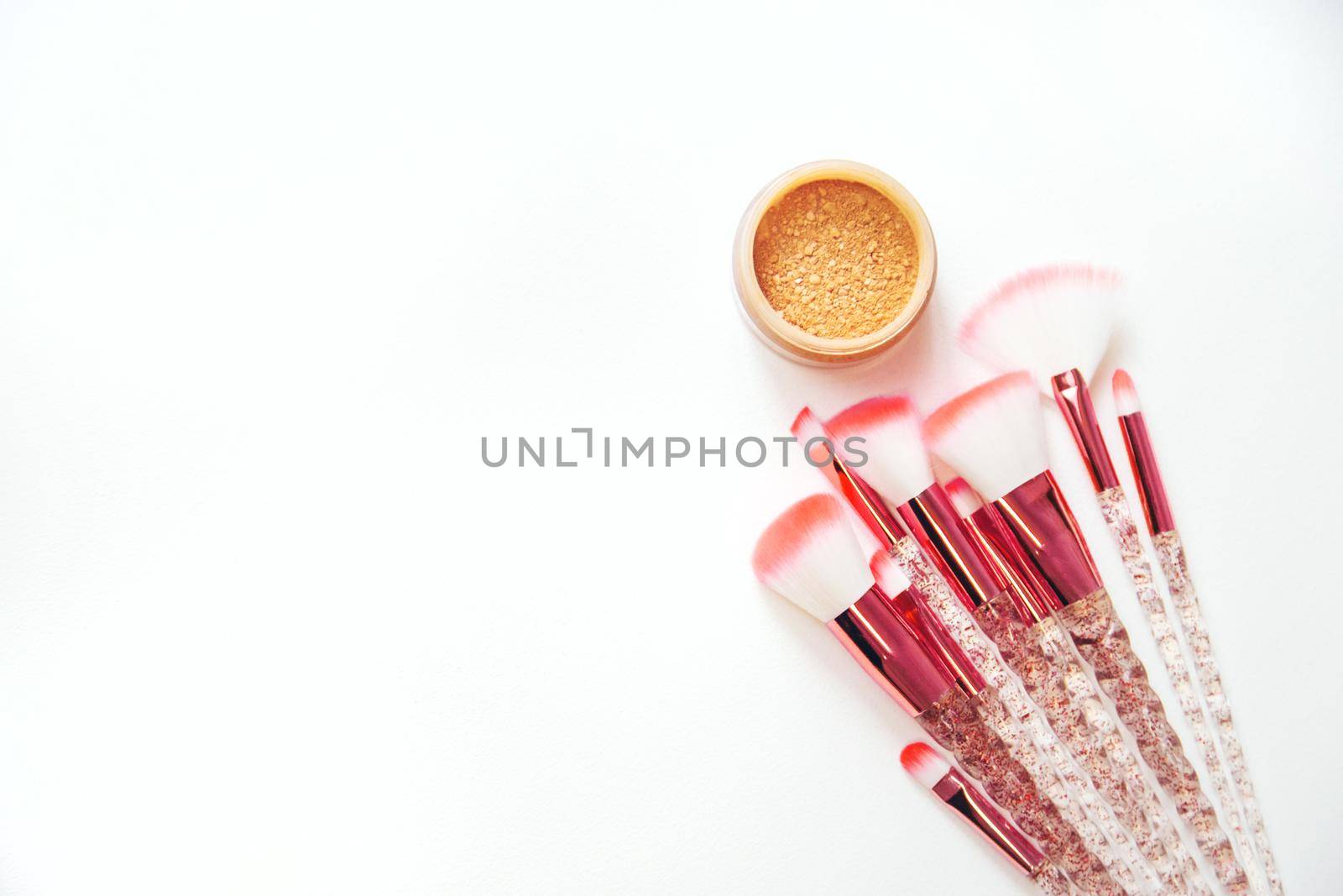 Makeup brushes and powder on a white background. Selective focus.