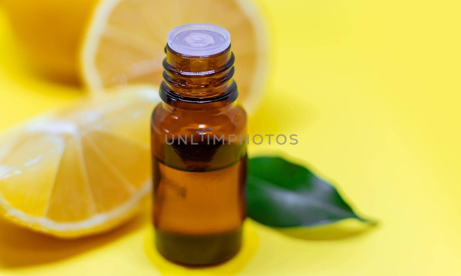 lemon essential oil on a yellow background. Selective focus. by mila1784