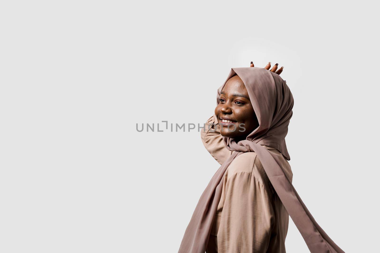 Happy and funny black girl on white background. Young muslim woman smiling in studio. Advert for social network.