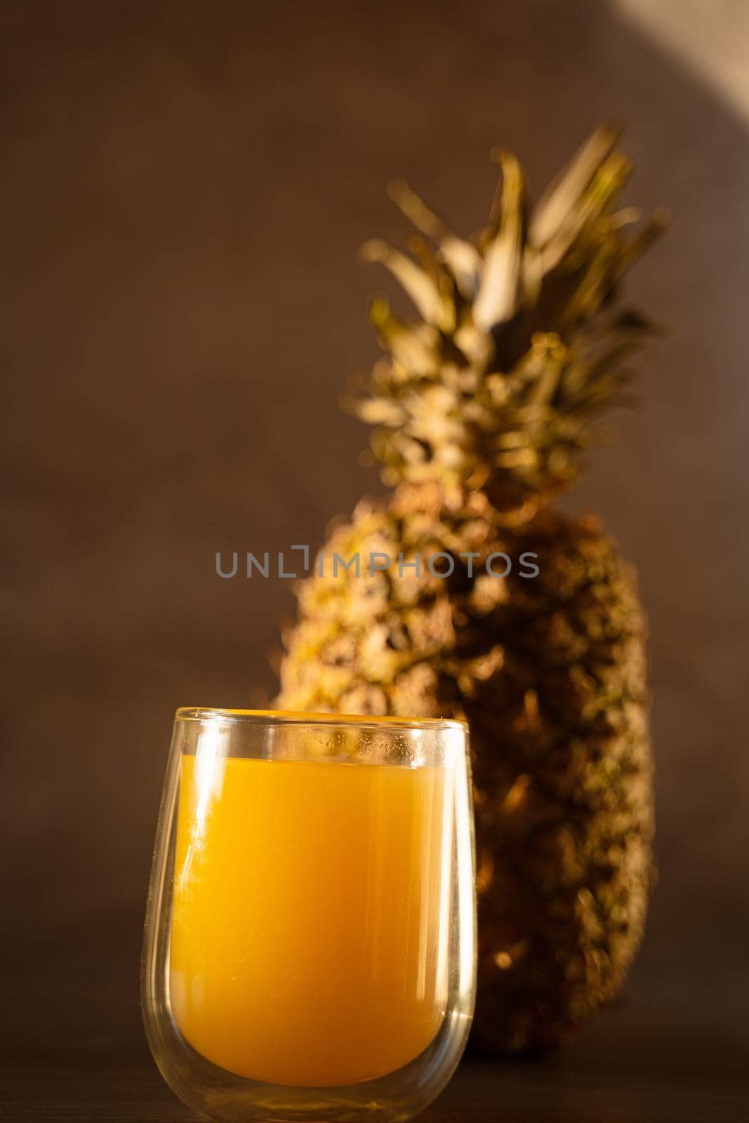 Pineapple fruit and juice in double glass cup. Tropical fruit . Pouring yellow tropical juice into glass by Rabizo