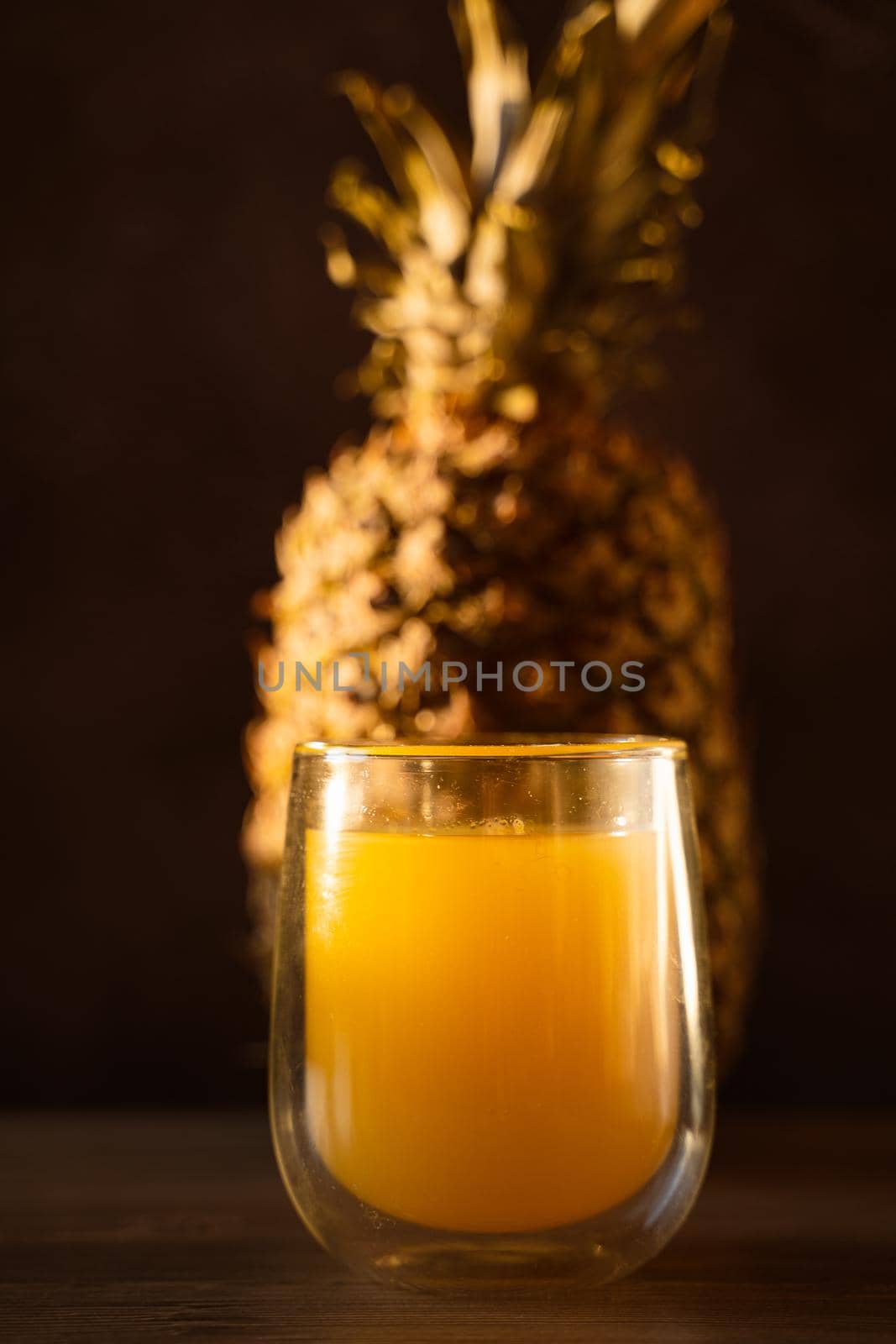 Pineapple fruit and juice in double glass cup. Tropical fruit . Pouring yellow tropical juice into glass.