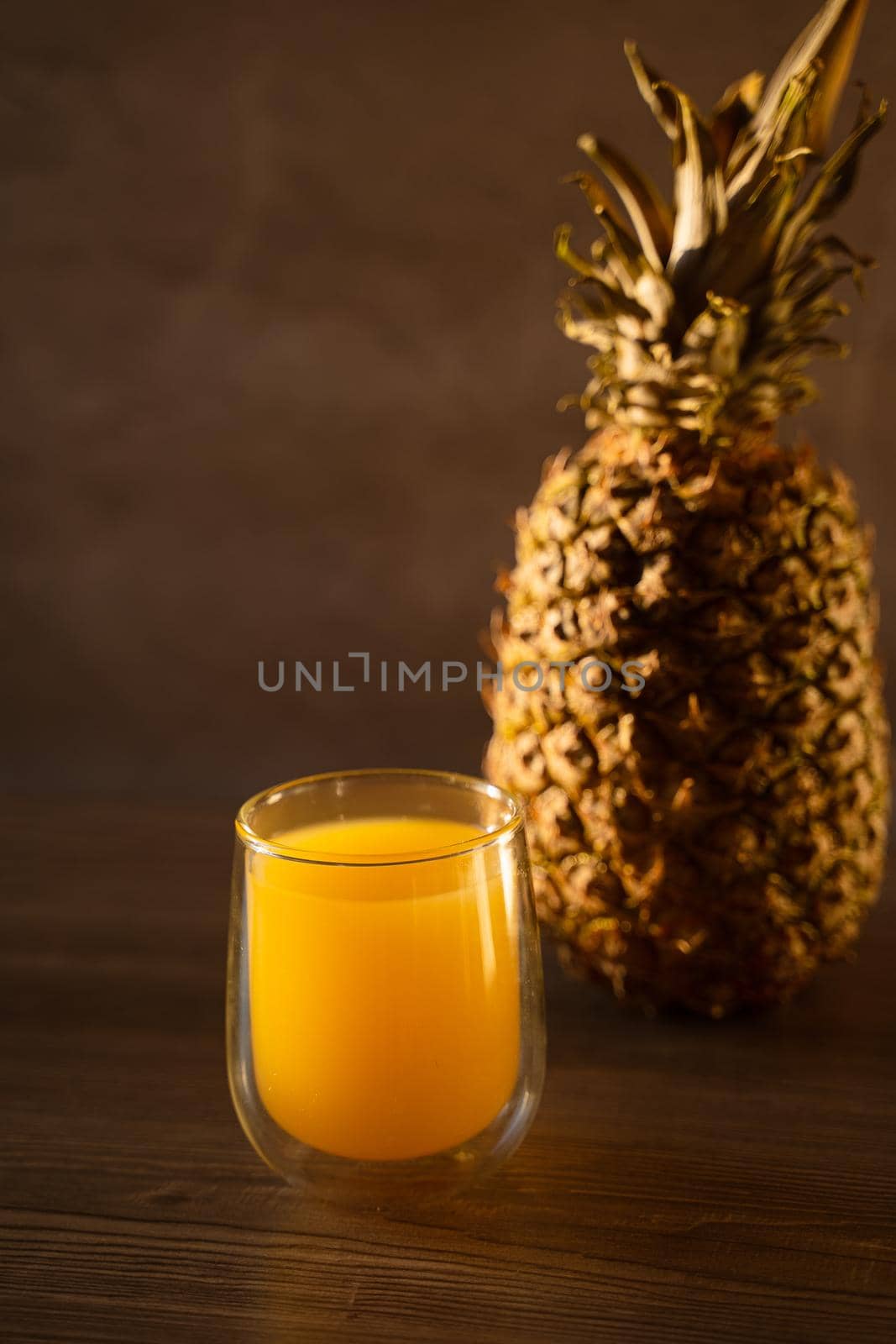 Pineapple fruit and juice in double glass cup. Tropical fruit . Pouring yellow tropical juice into glass.