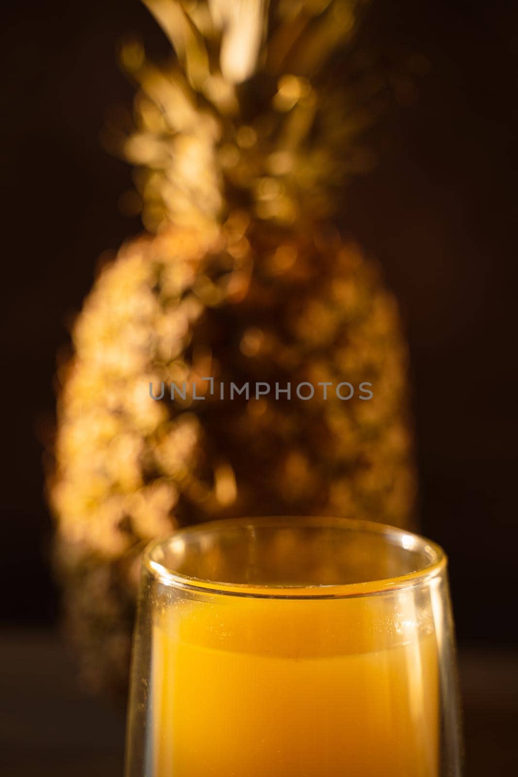 Pineapple fruit and juice in double glass cup. Tropical fruit . Pouring yellow tropical juice into glass.