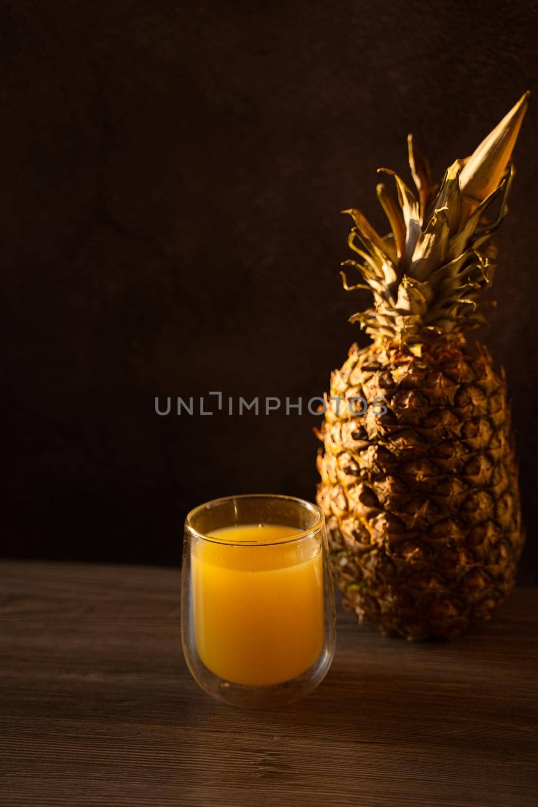 Pineapple fruit and juice in double glass cup. Tropical fruit . Pouring yellow tropical juice into glass by Rabizo