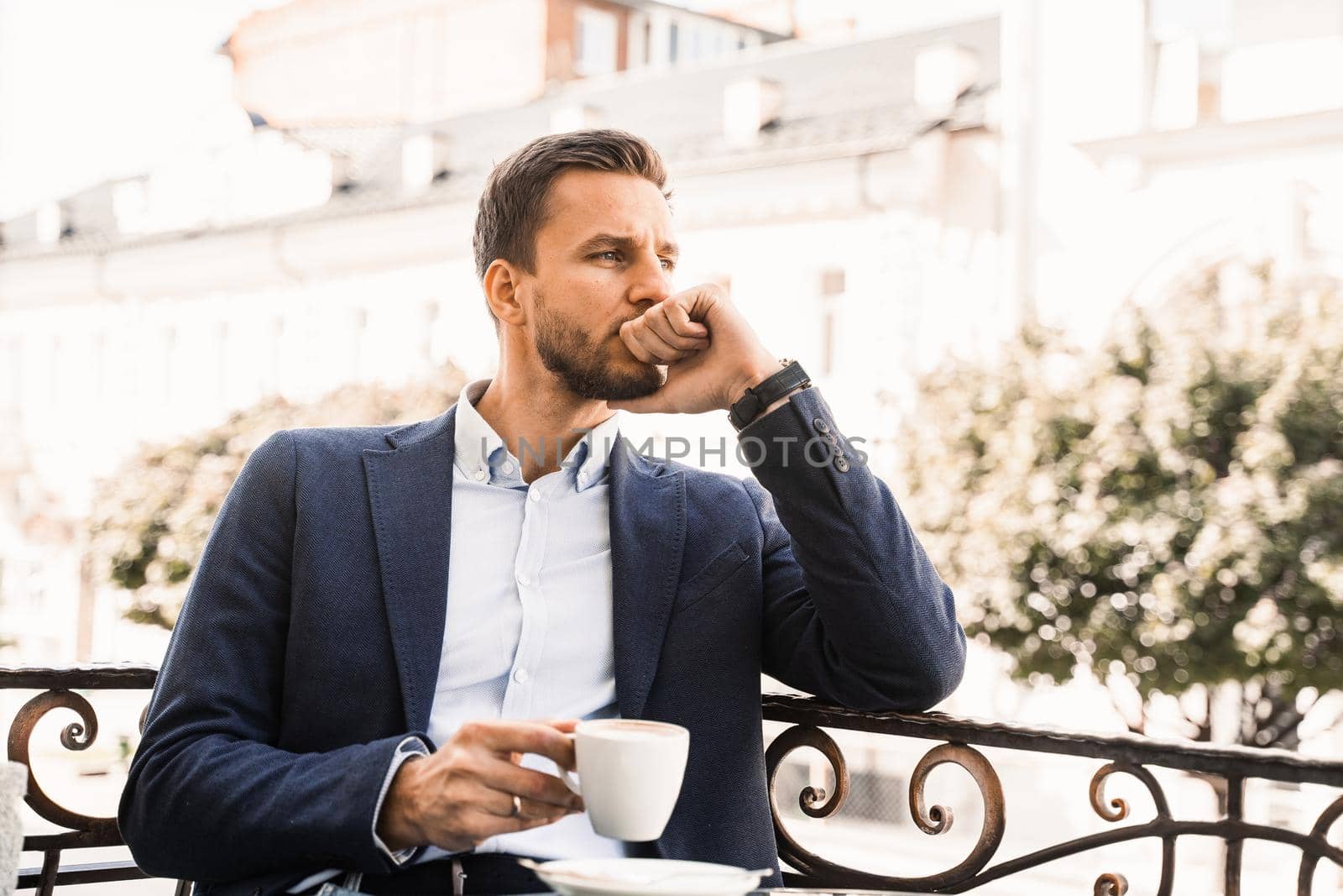 Handsome man with cup of coffee in cafe. Morning lifestyle of male. by Rabizo