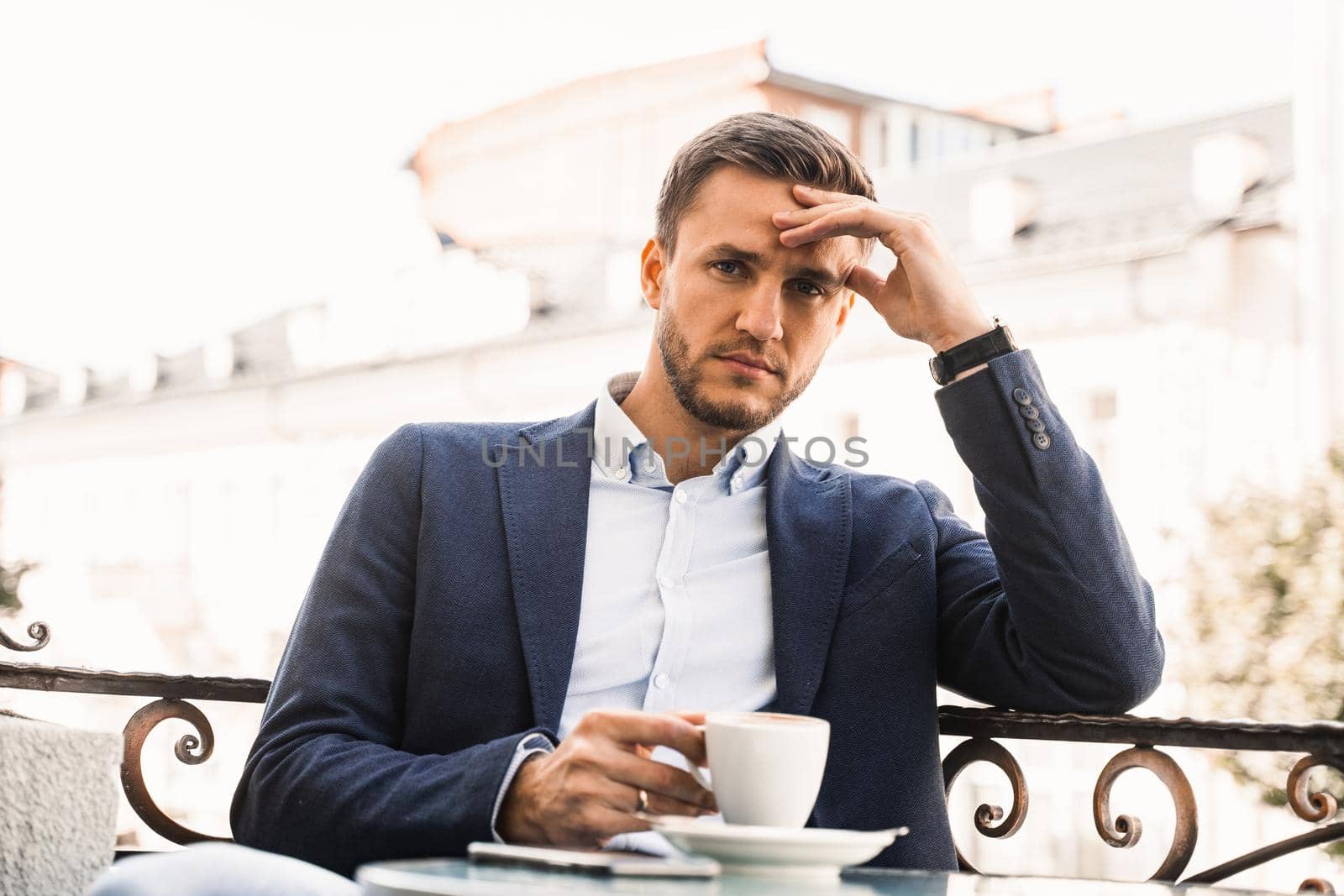 Handsome man with cup of coffee in cafe. Morning lifestyle of male