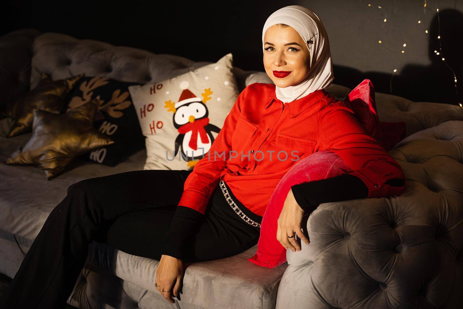 Muslim woman near christmas lights and decoration in studio. Professional muslim model posing at the new year eve.