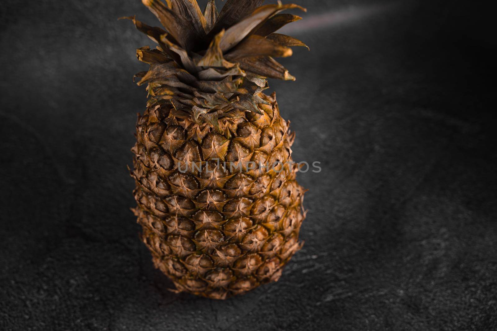 Pineapple tropical fruit on dark stone background background. Citrus fruit with vitamin c for helth care. by Rabizo