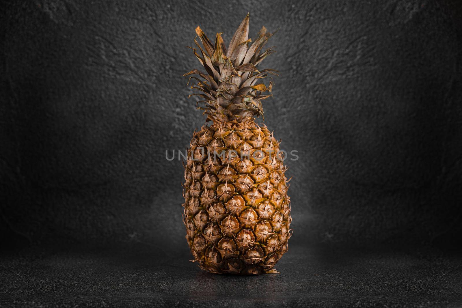 Pineapple tropical fruit on dark stone background background. Citrus fruit with vitamin c for helth care. by Rabizo